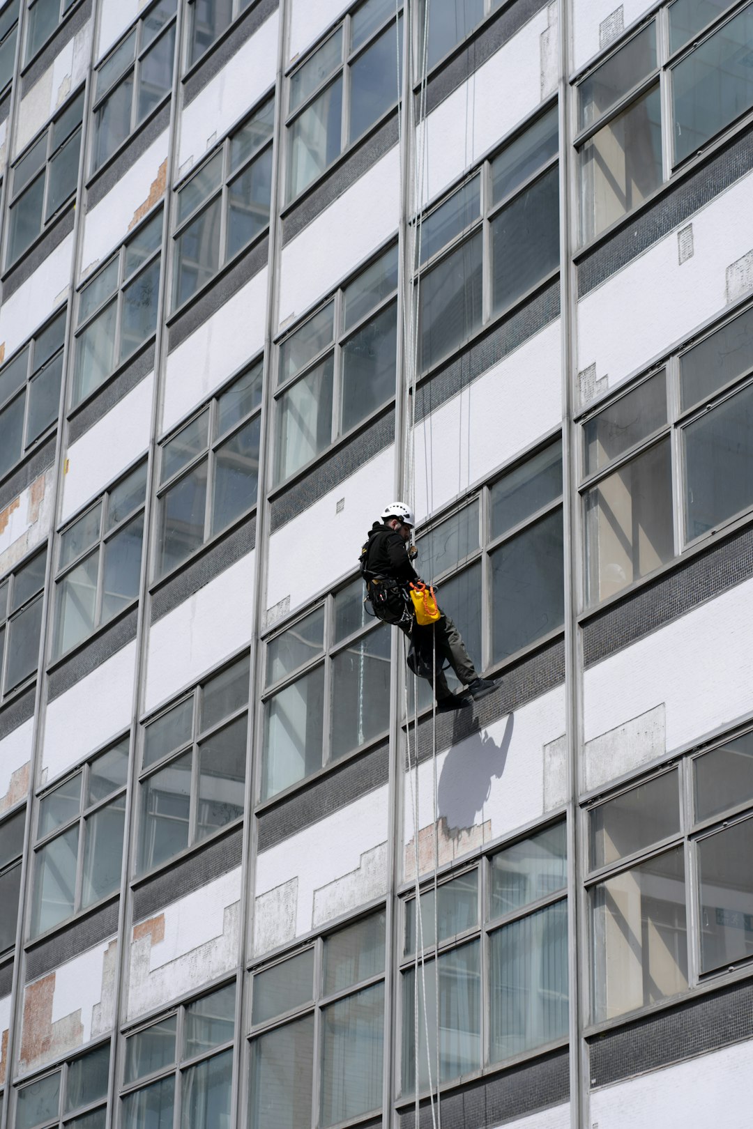 man-in-black-jacket-and-black-pants-standing-in-front-of-glass-window-building-during-daytime-xnqzjcjnumu